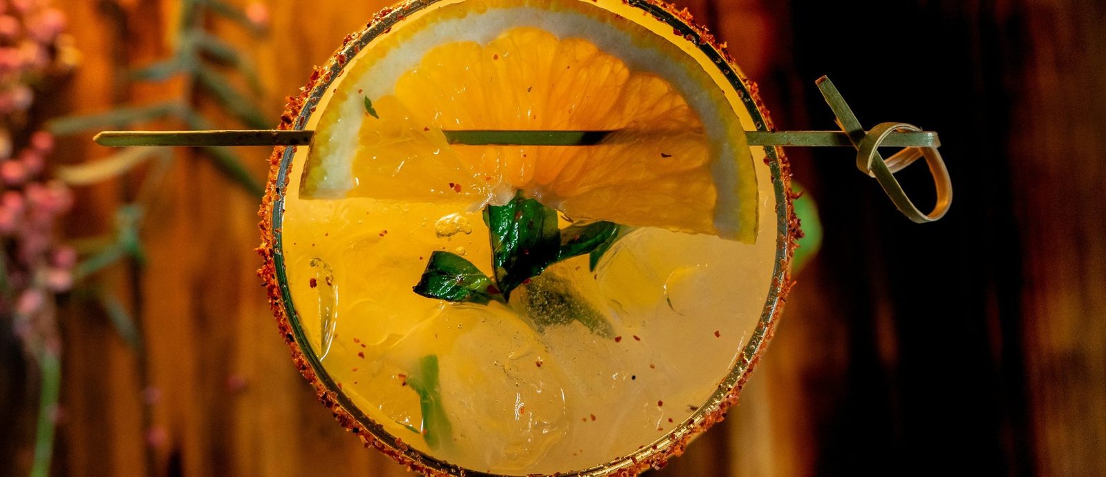 Vista cenital de un coctel con escarchado de tajín y rodaja de naranja